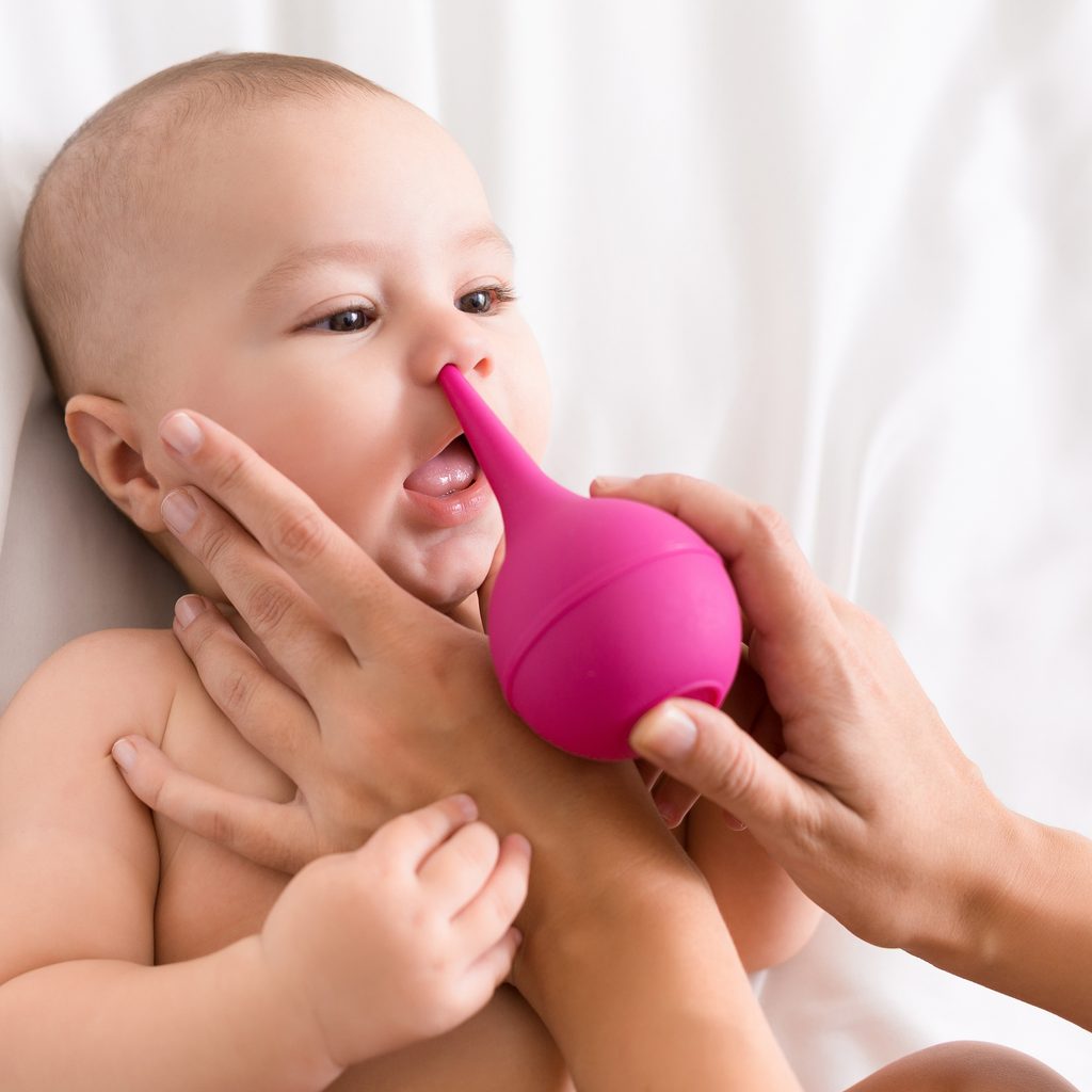 Newborn baby getting nose cleaning with cleaner