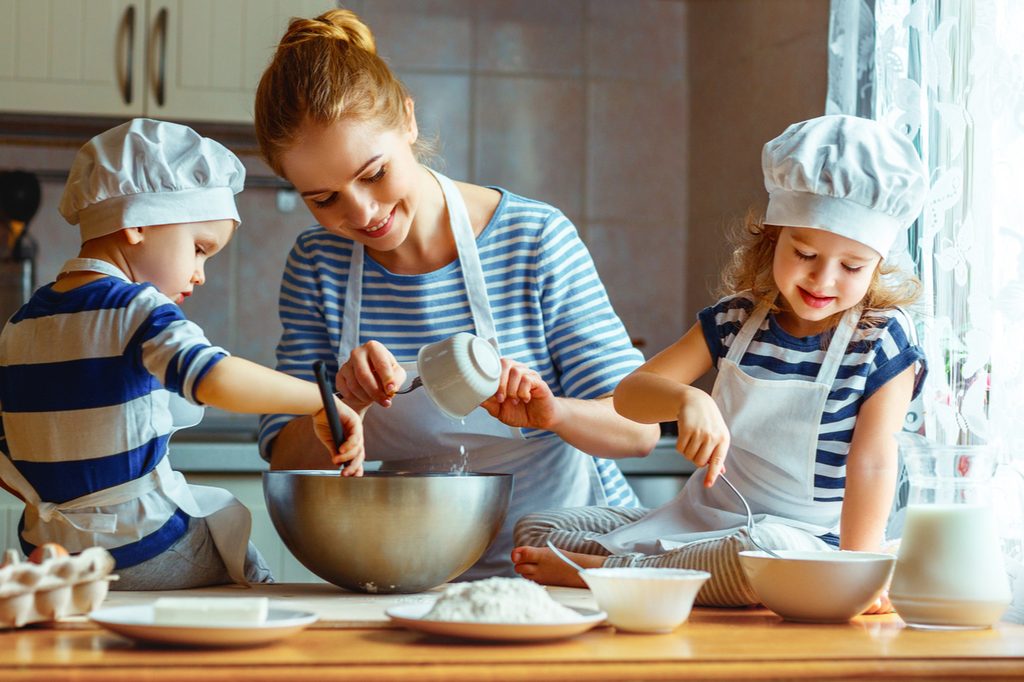Nanny and kids baking a cake