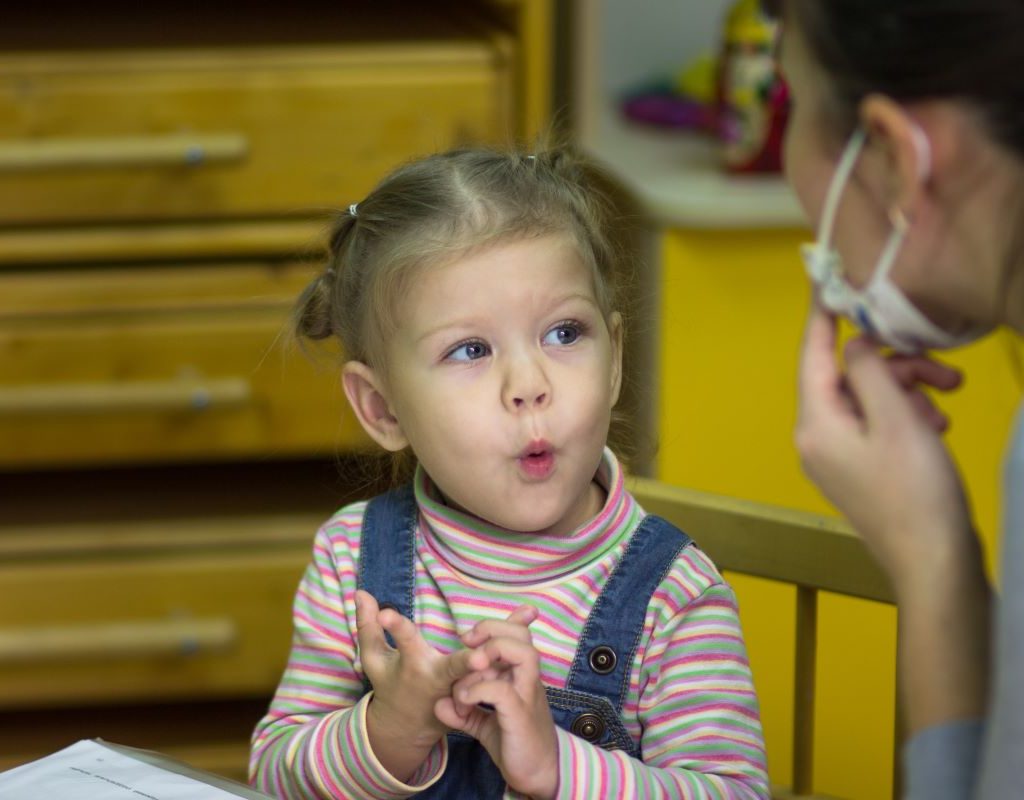 Speech therapist working with toddler girl