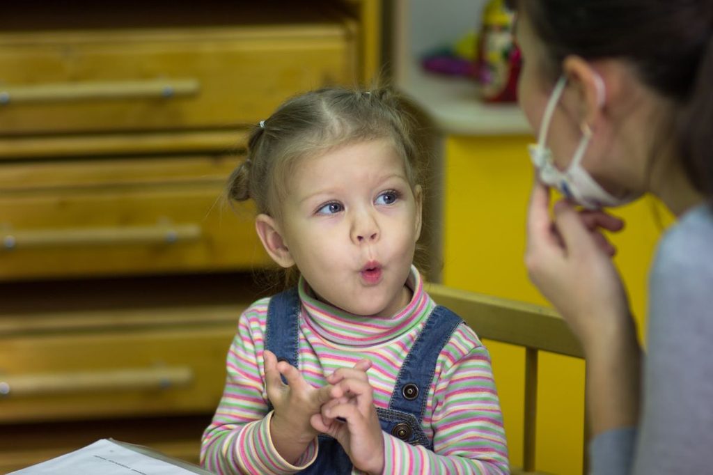 Speech therapist working with toddler girl