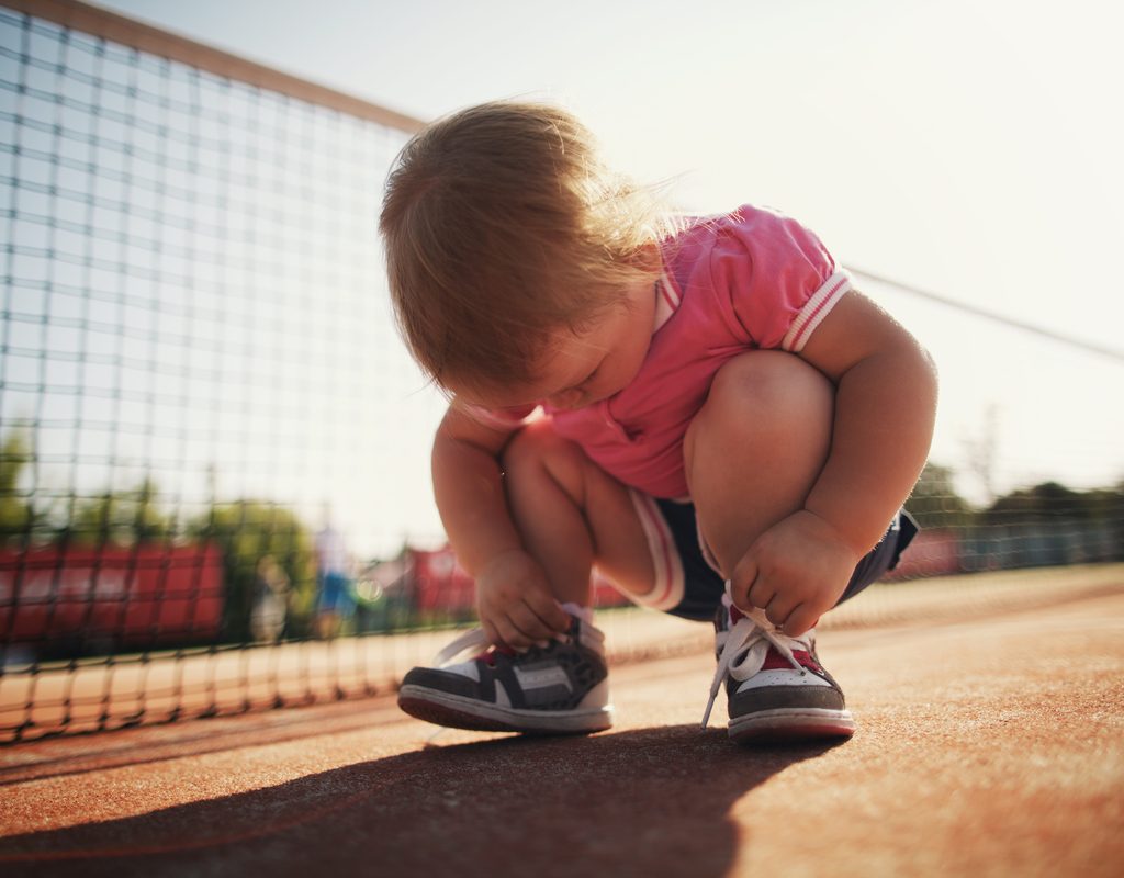 Toddler girls fascinated by her shoe laces