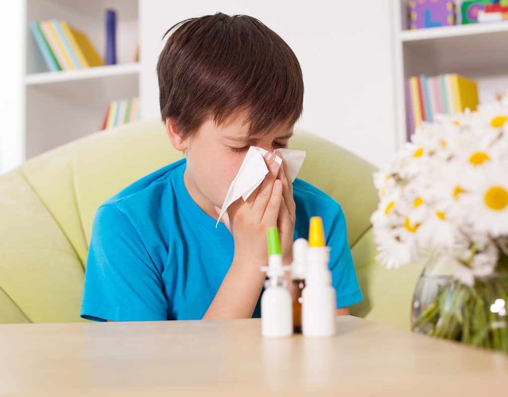 boy using nasal sprays and eye drops to help ease allergy symptoms