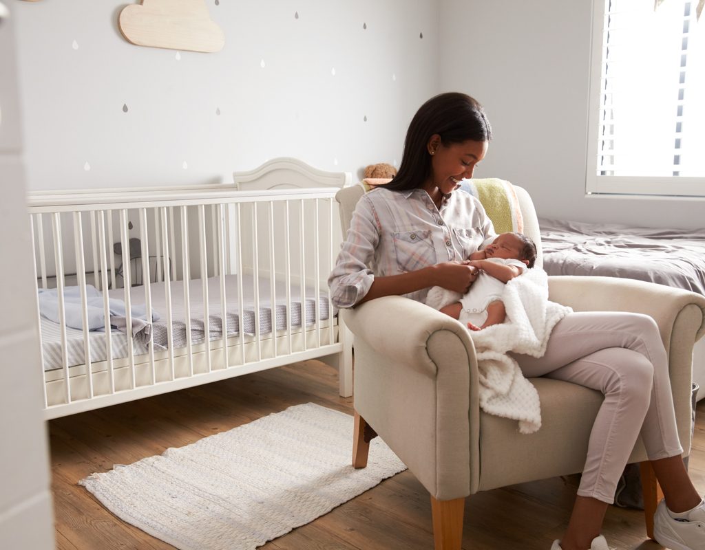 A mother holding her baby in the nursery.