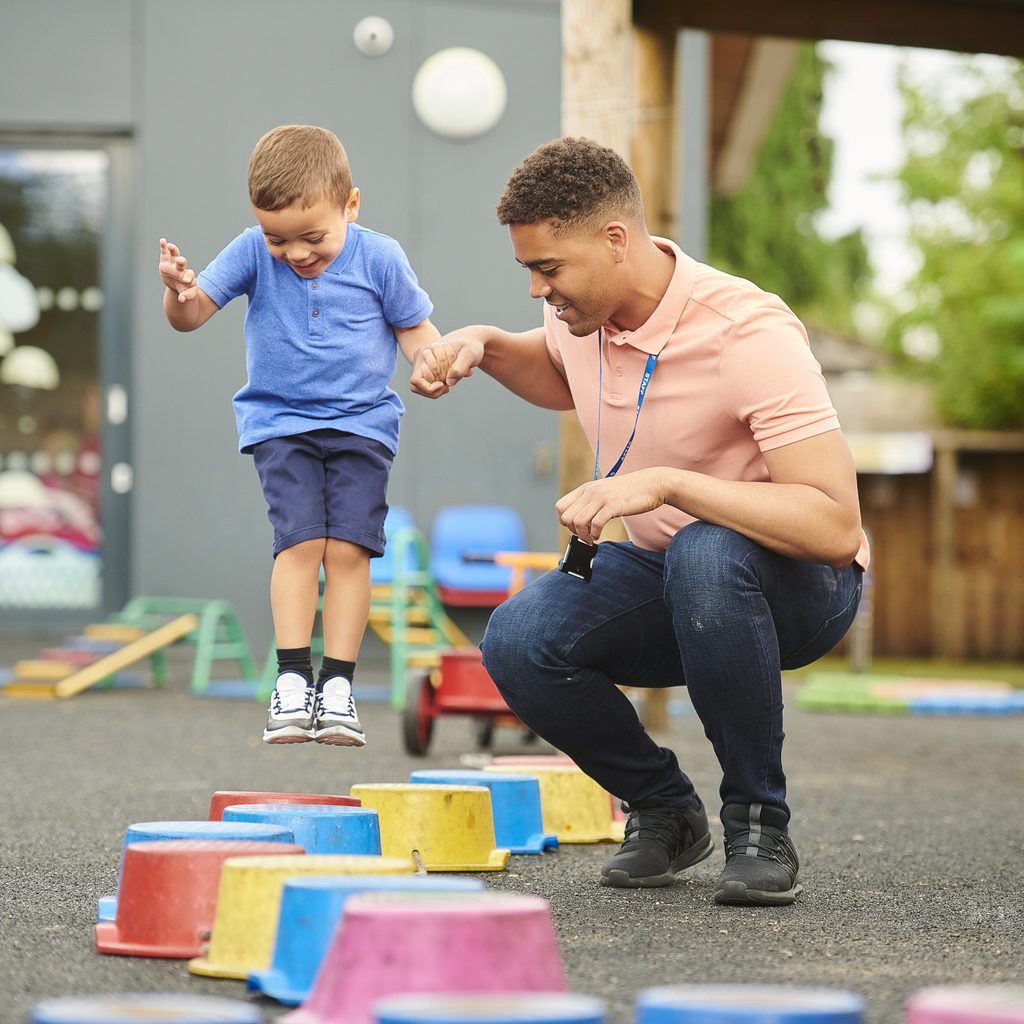 Day care teacher helping a child play a game
