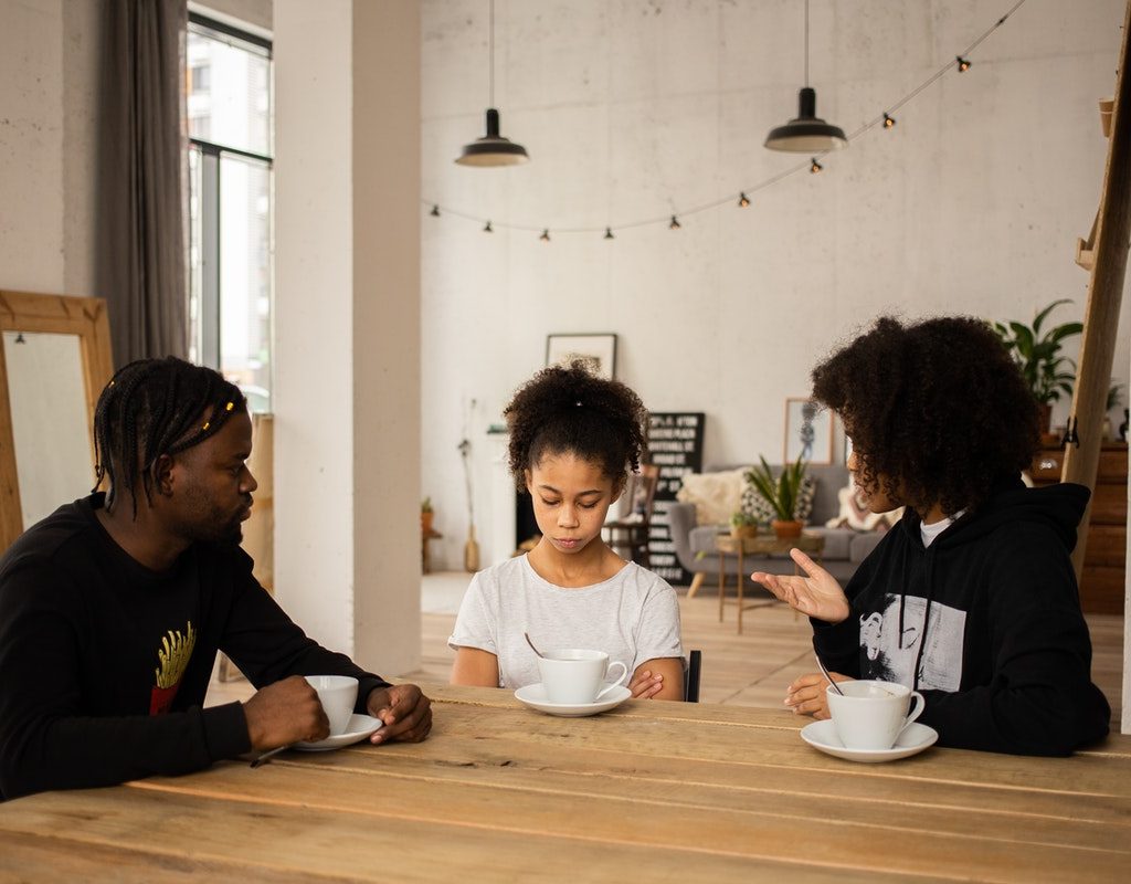 Parents sitting on either side of teen and scolding her
