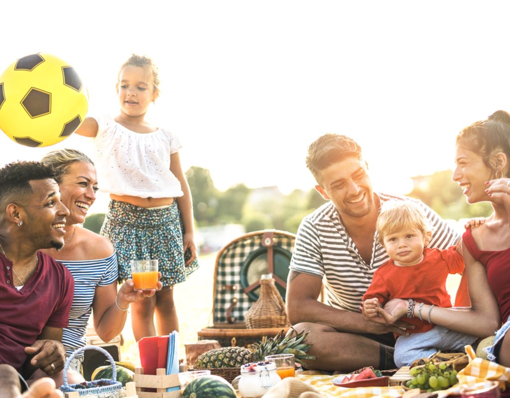 A group of families sitting around the table together at a campsite