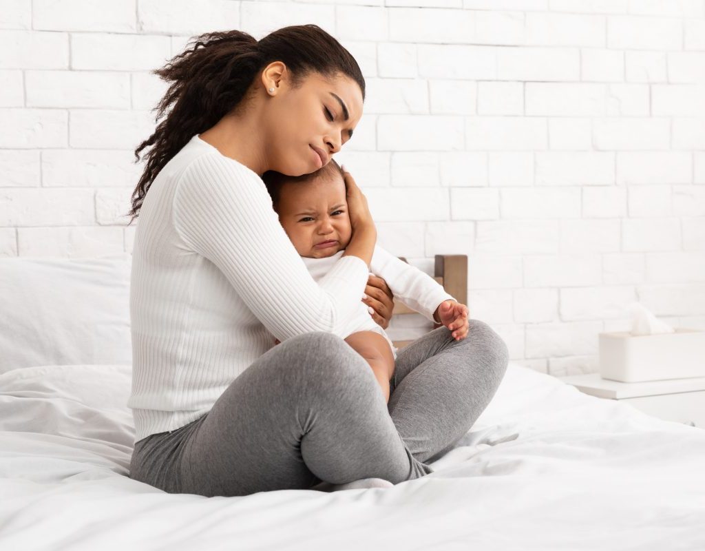 A mother comforting a crying baby.