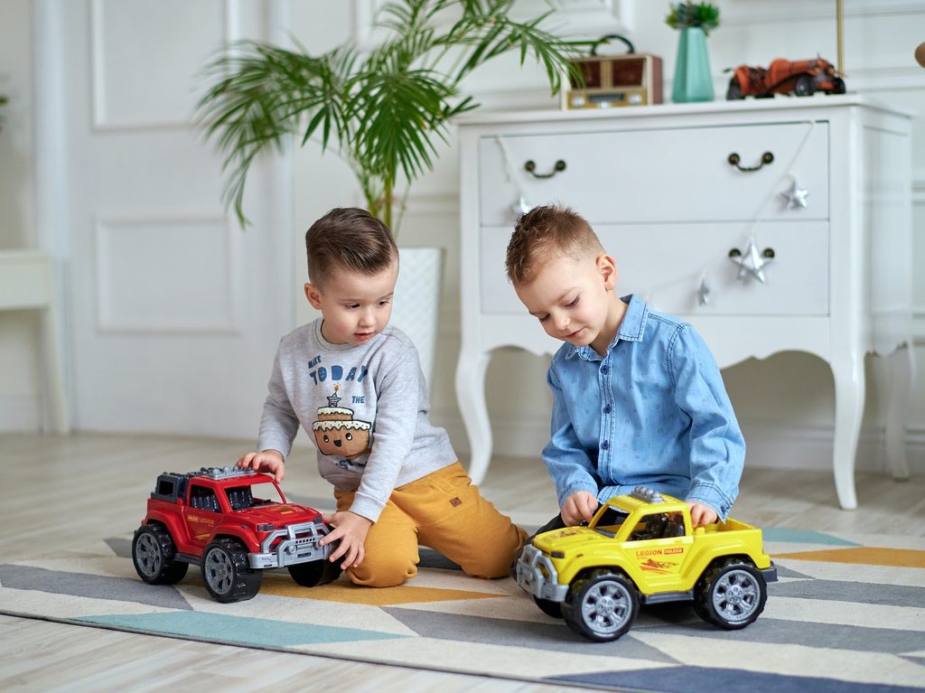 Boys playing with truck toys.