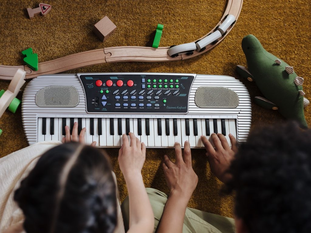 Kids playing with electronic instrument.