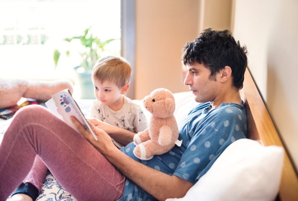 A father reading a book to their young child