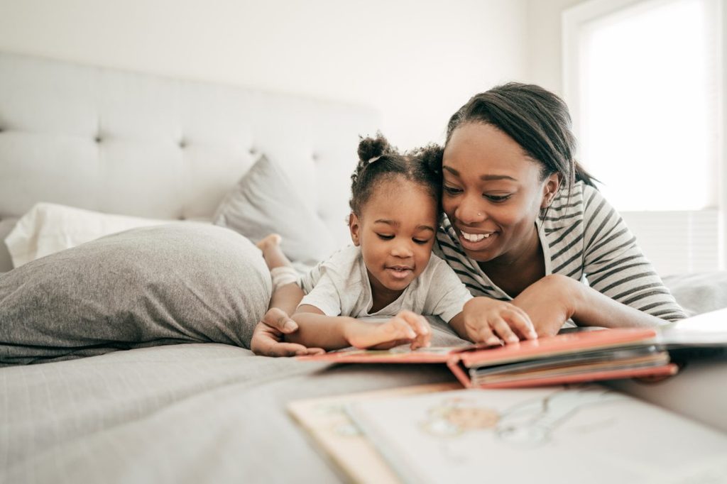 A mother reading her young child a bedtime story.