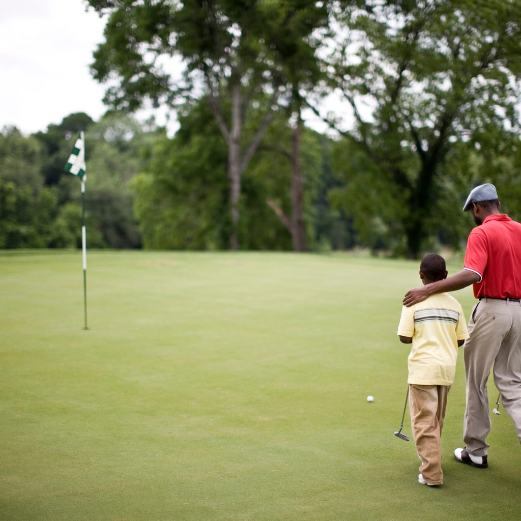 Father and son walking on the golf course on Father's Day