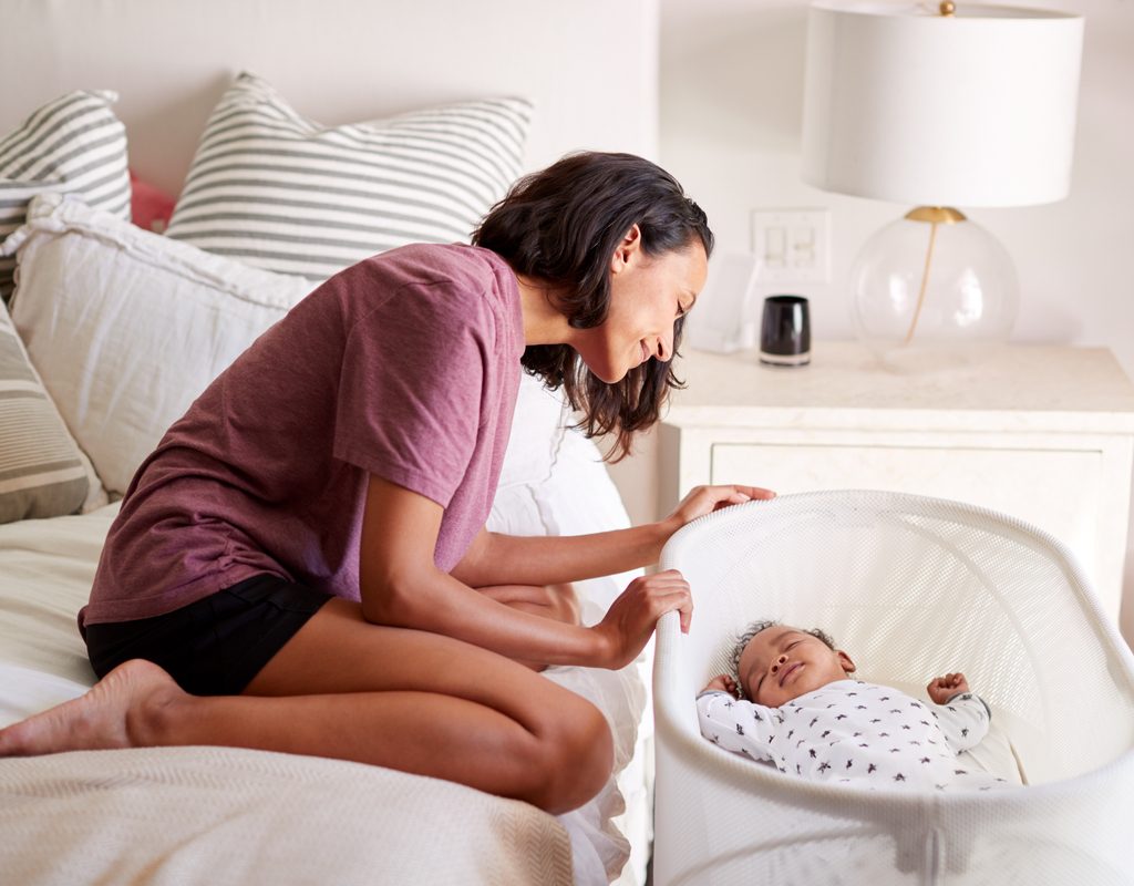 A mother looking in on her sleeping baby