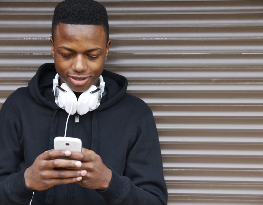 A male teen on his cellphone.