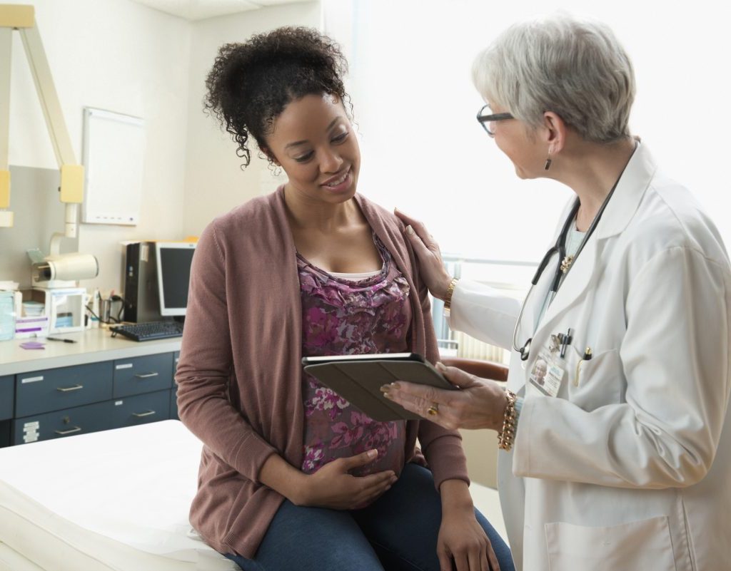 A pregnant woman talking to her health care provider.