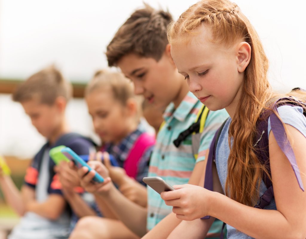 Group of tweens all using cellphones