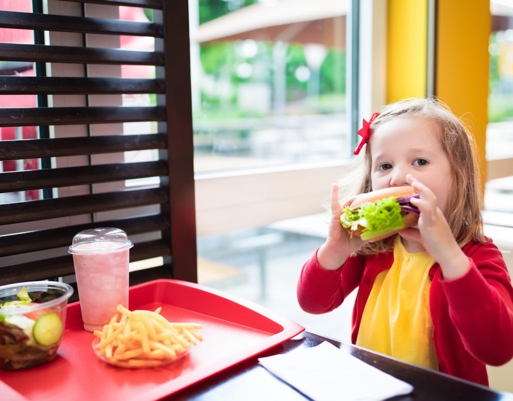 A young girl eating a fast-food meal