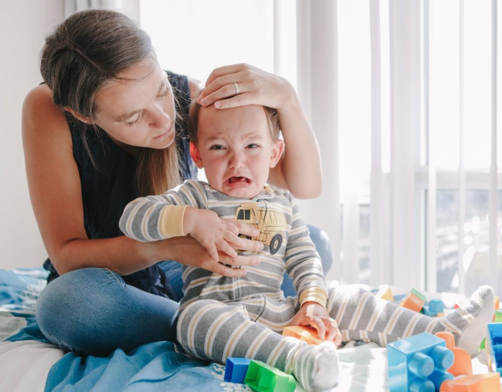 A mother trying to calm down her angry toddler.