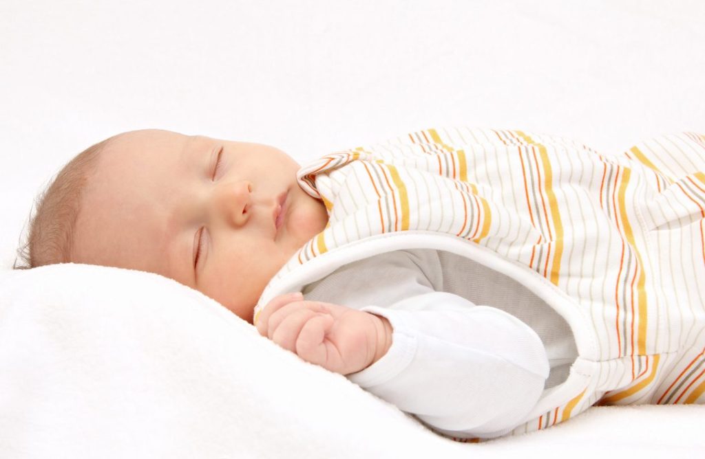 A baby sleeping in a sleep sack.