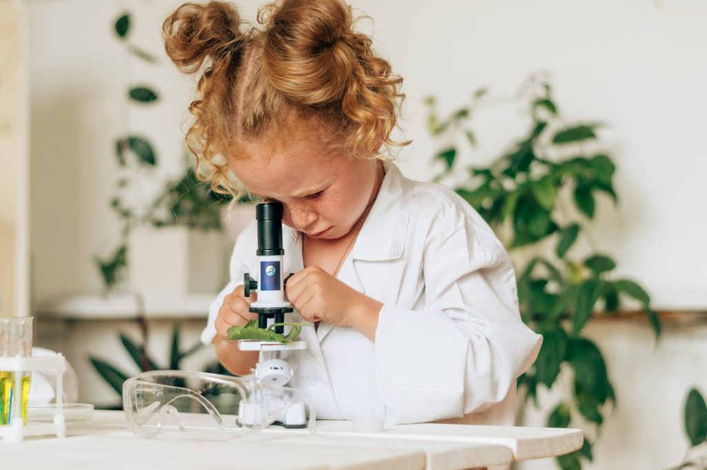 A little girl looking in a microscope.