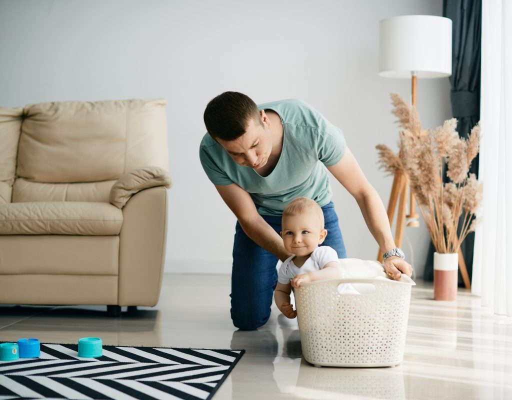 A parent pushing their baby in a laundry basket