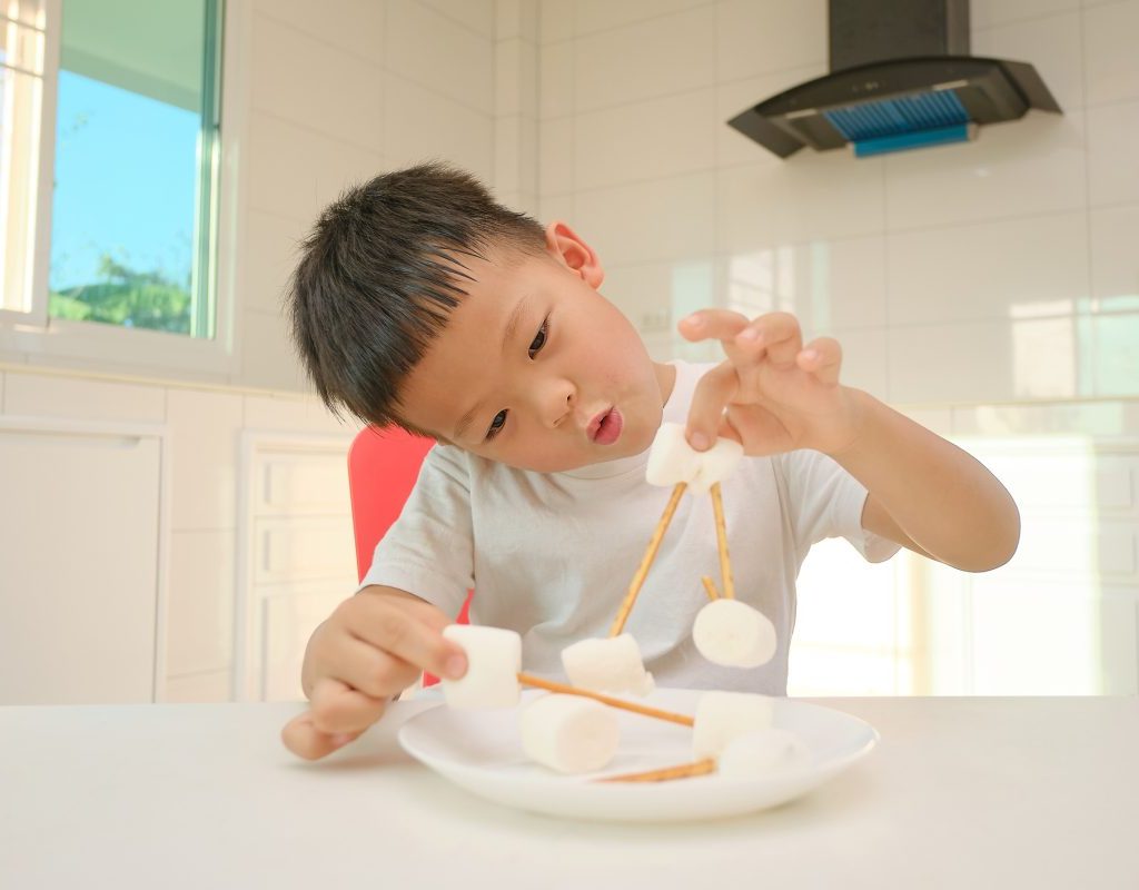Young boy playing with his food