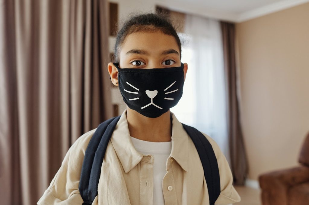 Child wearing a dark cat mask
