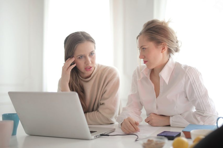 Mother and daughter sitting in front of computer