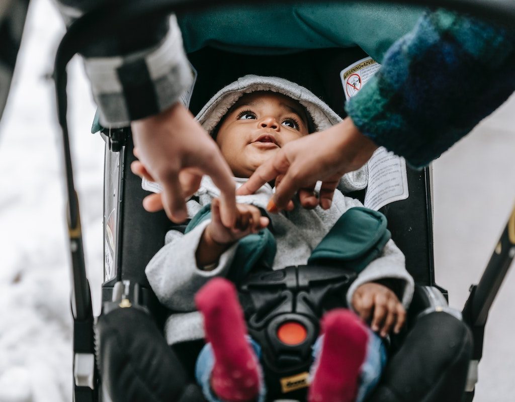 Parent playing with baby in stroller