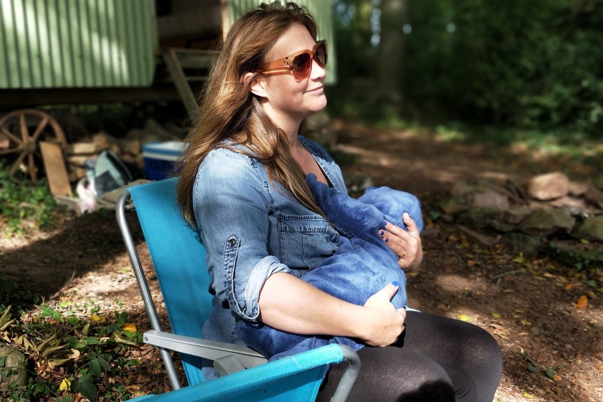 Woman breastfeeding older infant outside