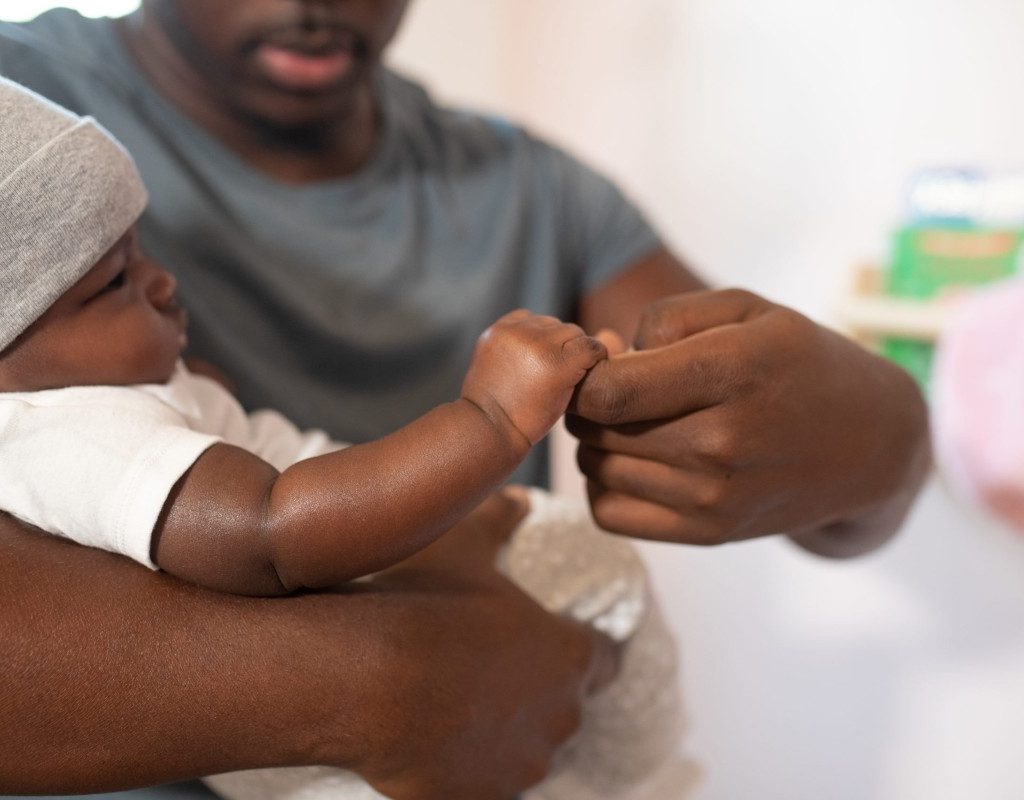Father holding his baby's hand