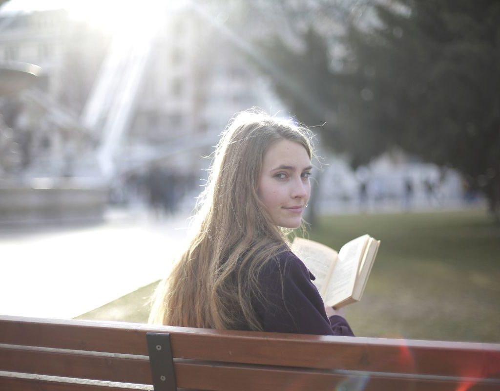 Girl on a bench with a book