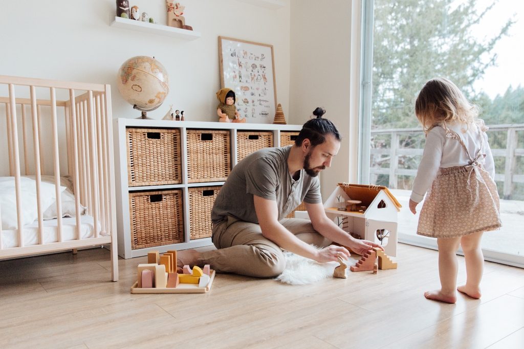 A dad and daughter playing with toys together