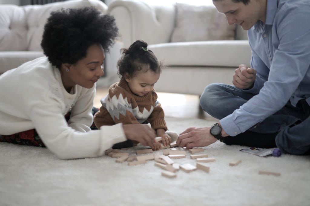 Two parents playing with blocks with a child