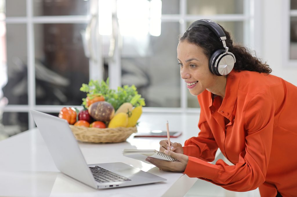 Woman listening to music and taking notes