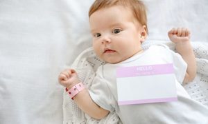 Baby girl with a "hello my name sign is" on her onesie