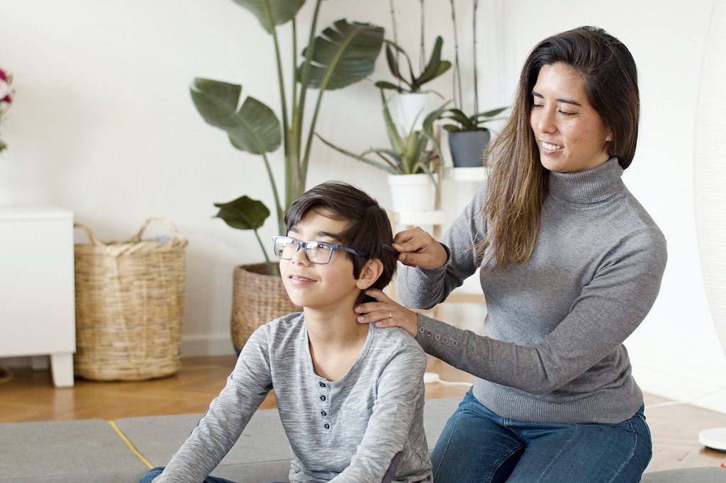 A mother combing her son's hair