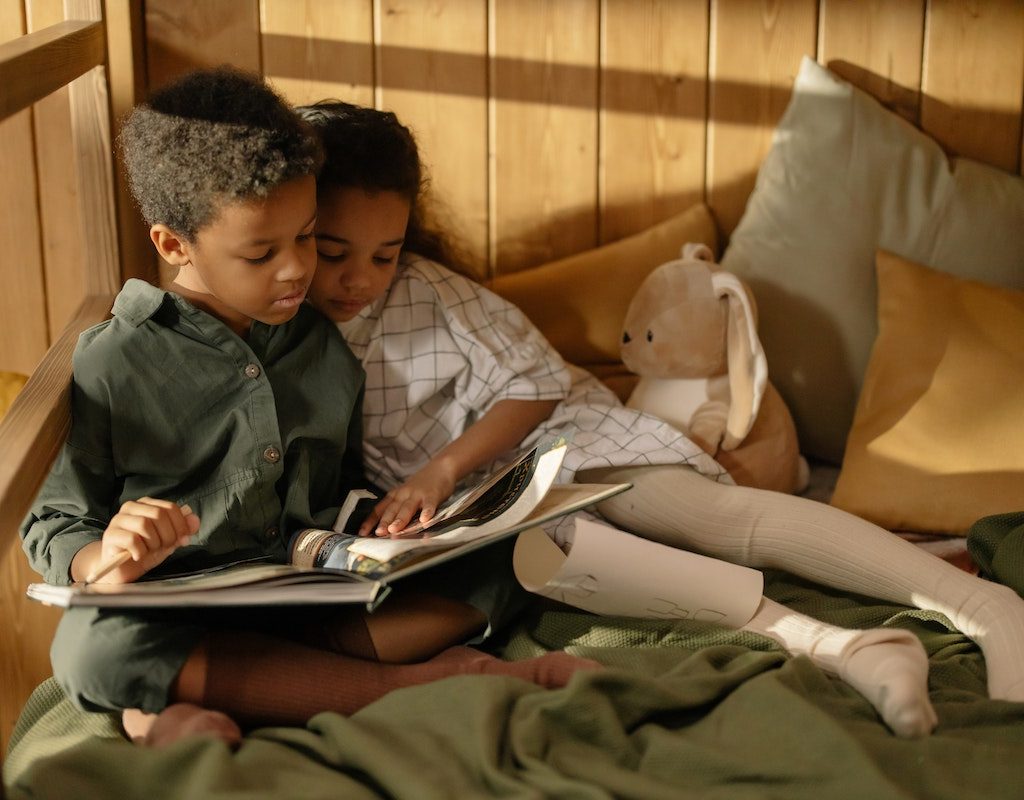 Two children reading in bed