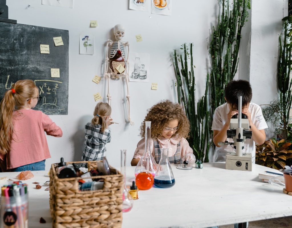 Kids in science room with chalkboard and microscopes