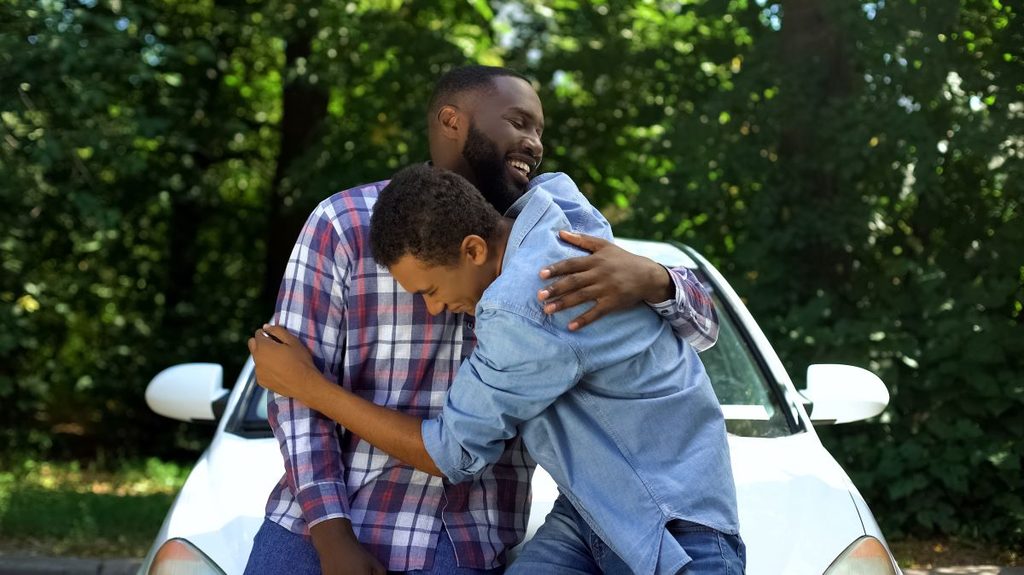 Excited son hugs dad after getting a car