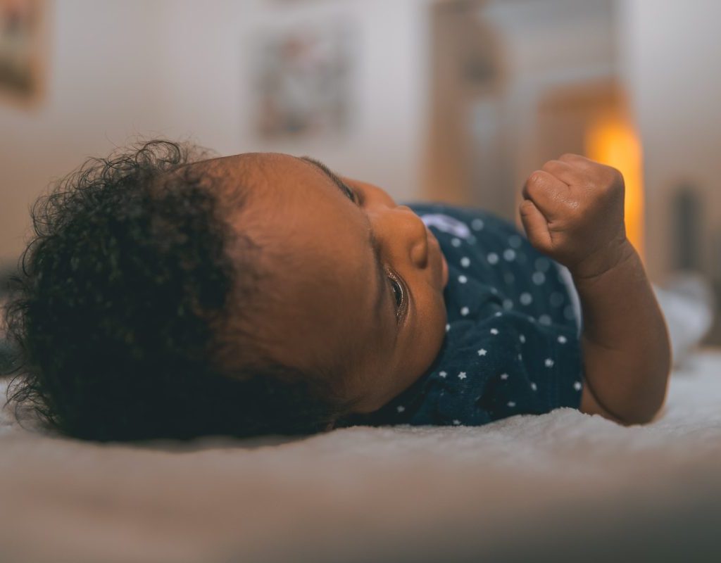 Baby laying down on flat surface