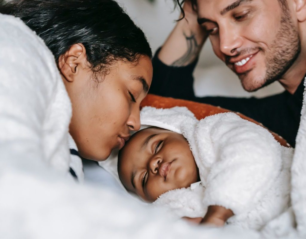 Parents cuddling with their little baby.