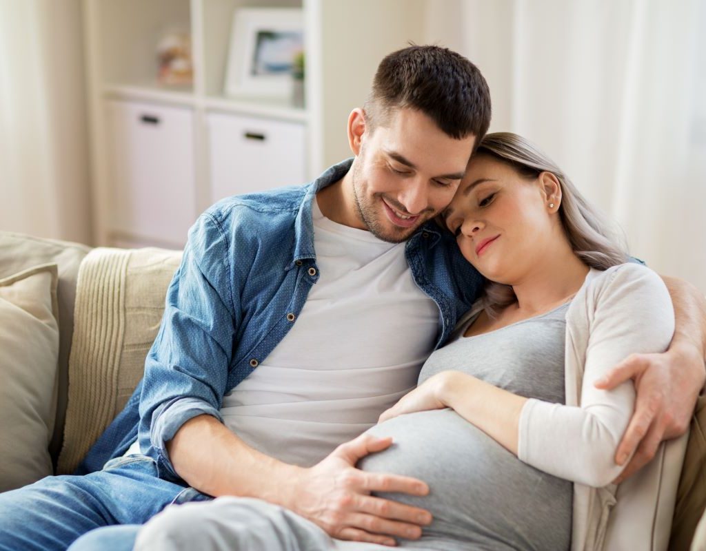 Pregnant couple cuddling.