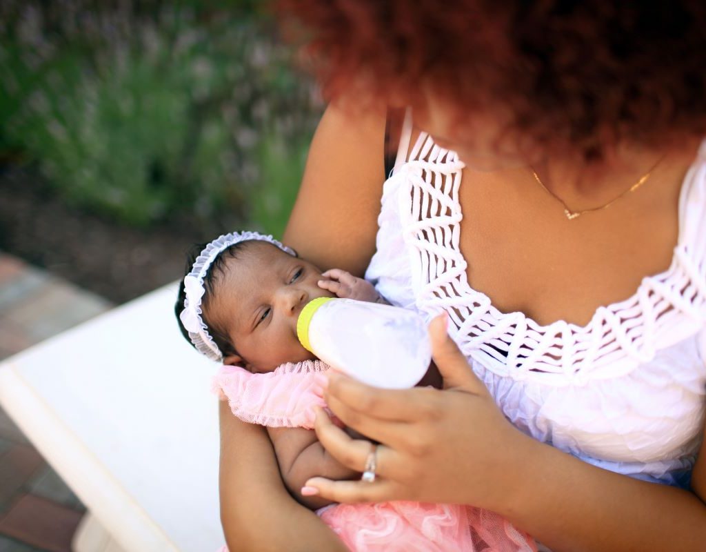 Mom feeding her baby outside.