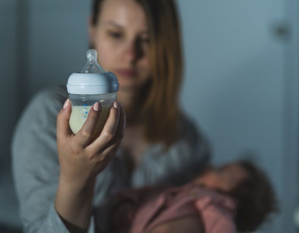 Mom looking at bottle to see if baby has drank enough.