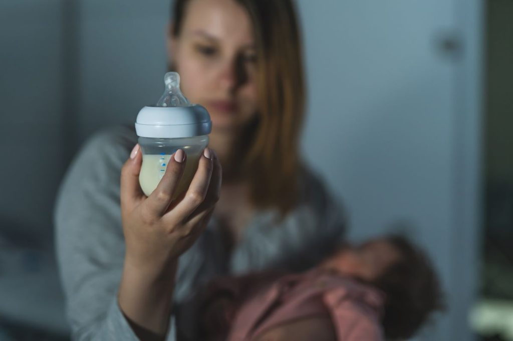 Mom looking at bottle to see if baby drank enough