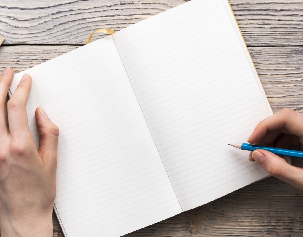 A person about to play a paper game in a notebook