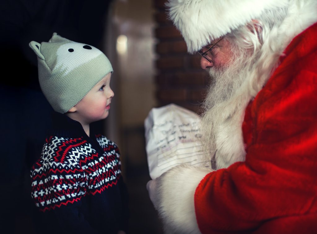 Santa handing a present to a child.