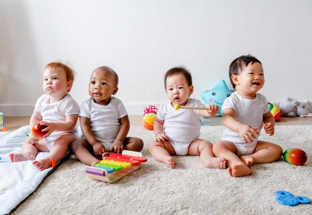 Four babies sitting together at daycare.