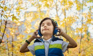 Young boy listening to a podcast on a walk